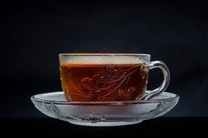 a glass cup filled with liquid sitting on top of a saucer